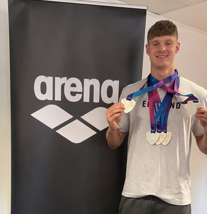 Ollie Morgan, University of Birmingham alumni, holding up his five silver medals.