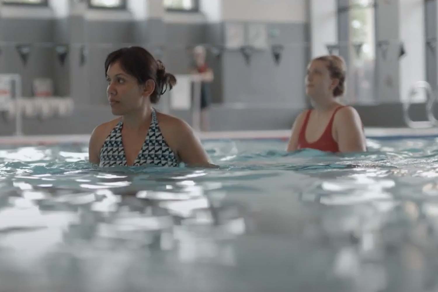 Two women standing in the pool during an aqua class