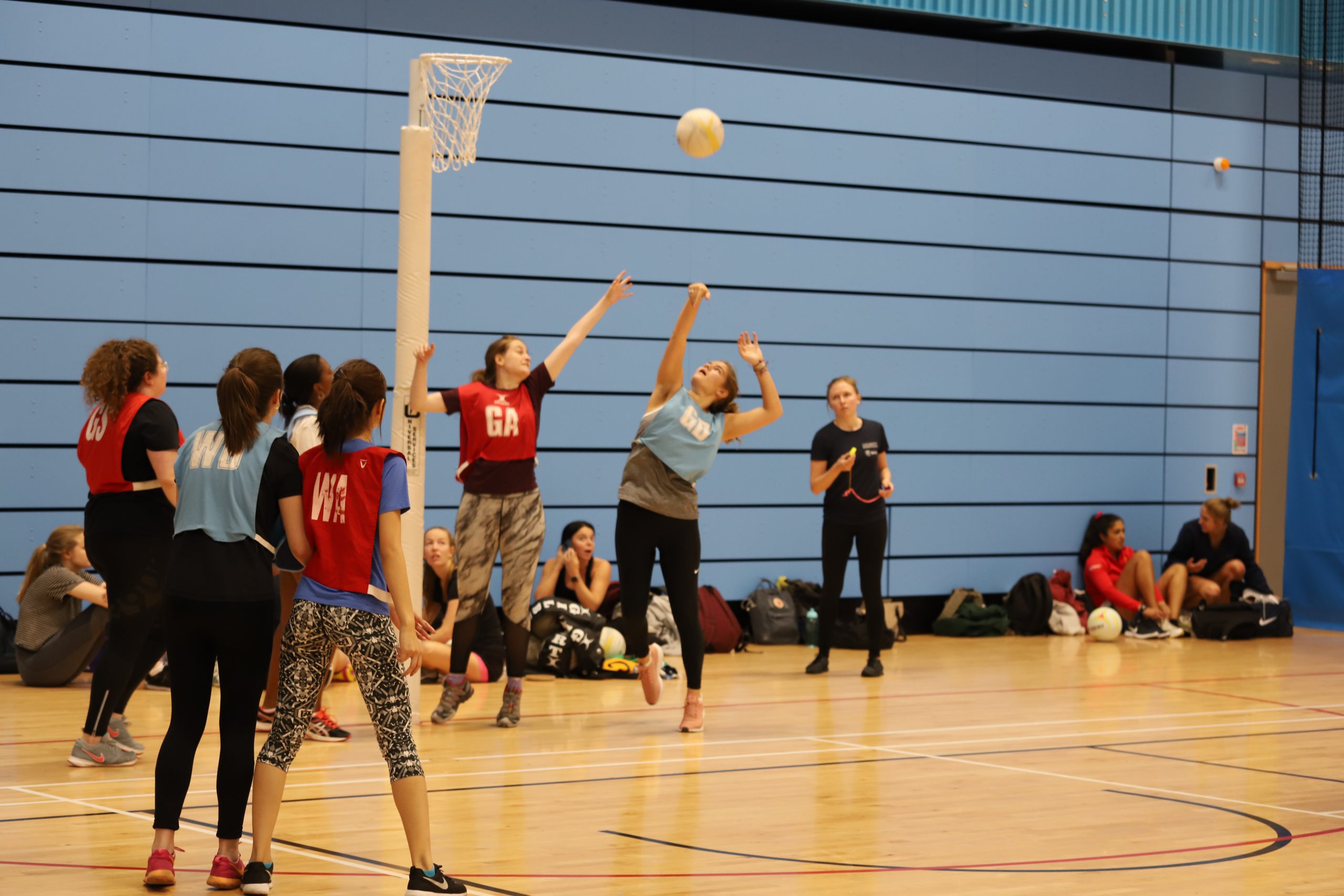 Group of Netballers fighting for the ball in a sports hall