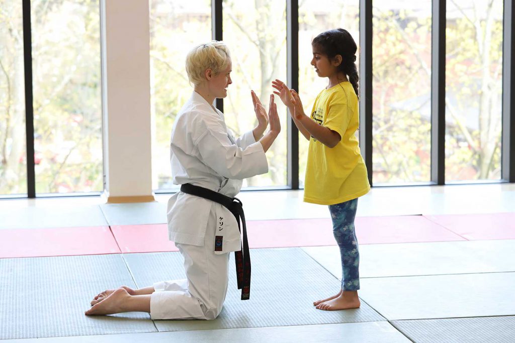 Instructor and junior in a martial arts class