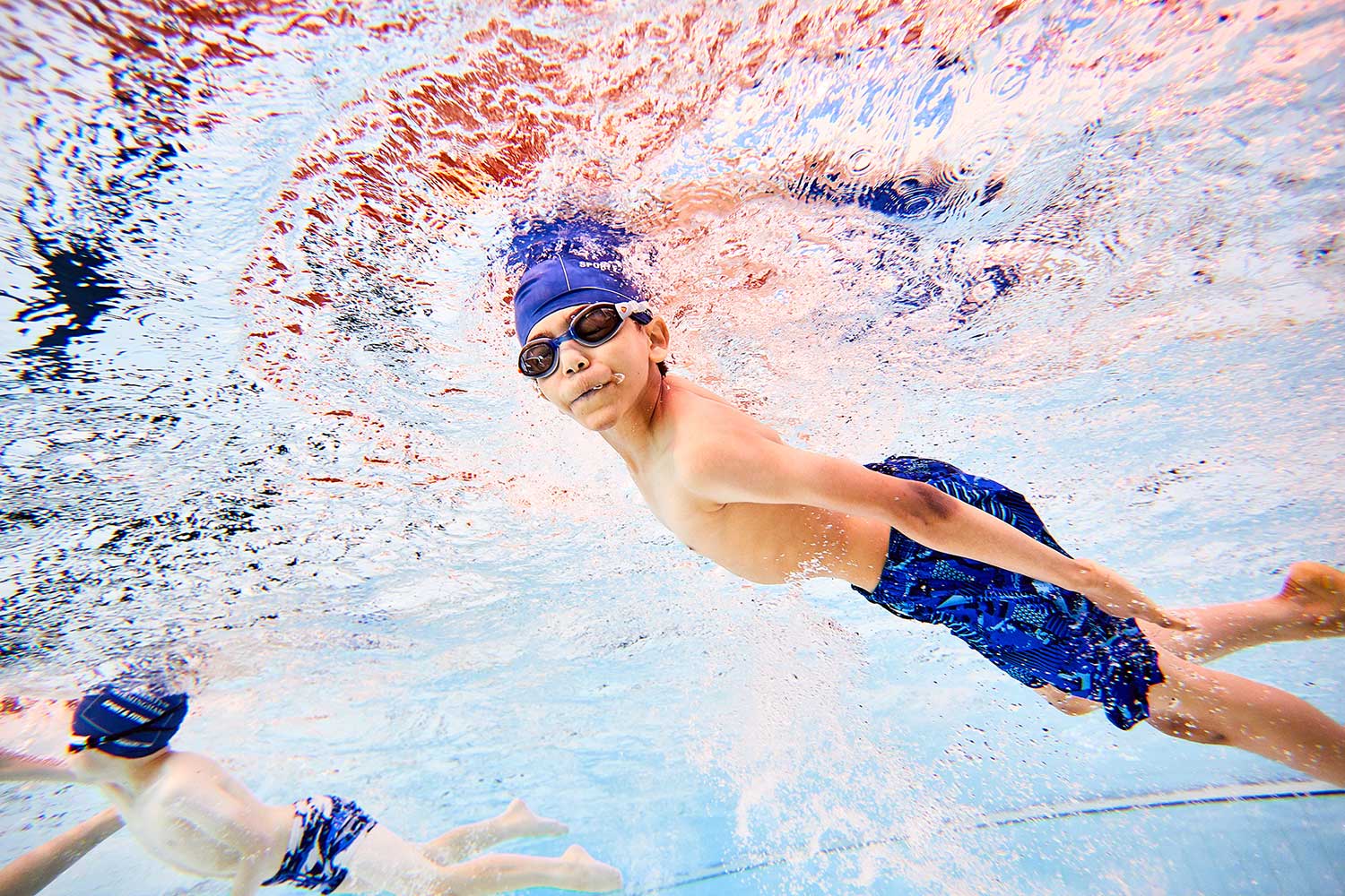 Junior swimming underwater in the pool