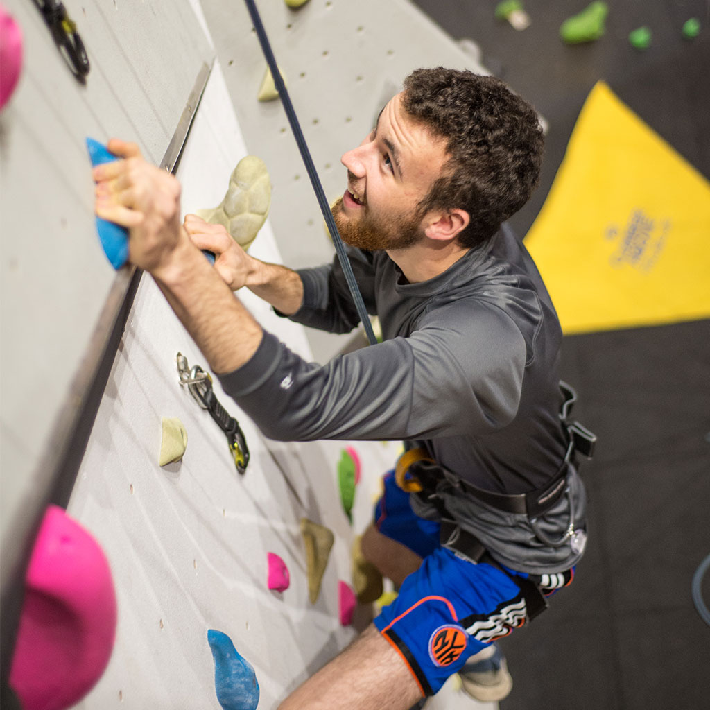 Adult on the climbing wall smiling