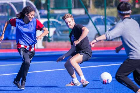 1 female and 2 males playing football