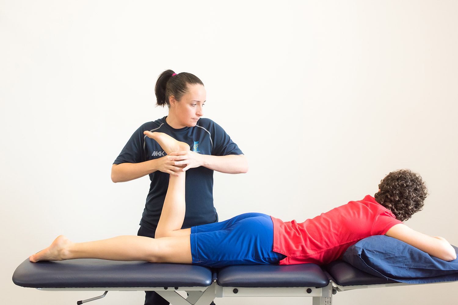 woman on a physio bed having her leg checked