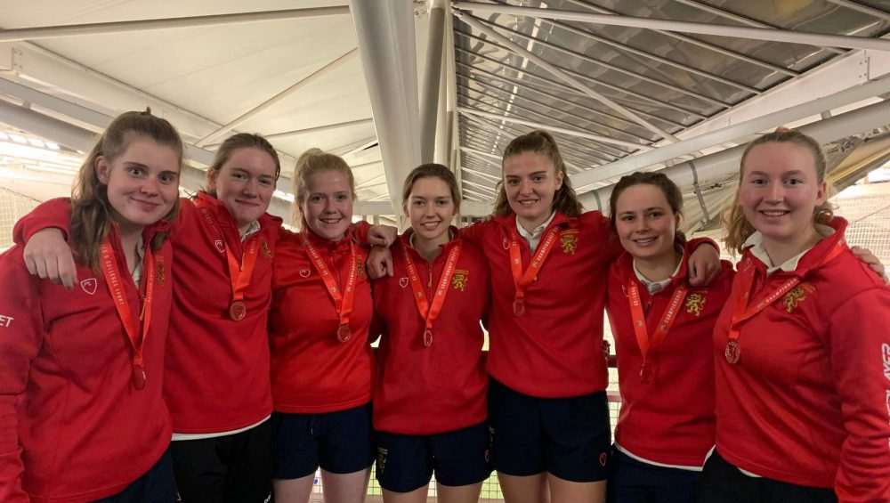 Seven of the women's cricket team stoof with their bronze medals at the National Indoor Finals