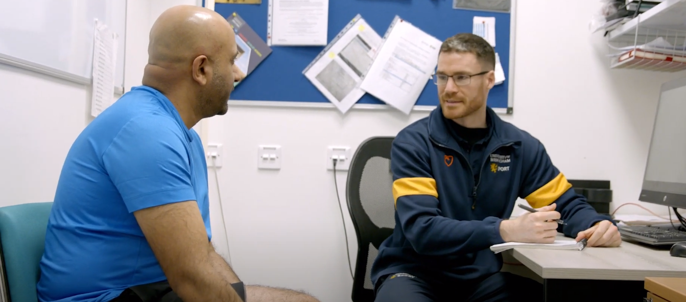 Two adults sat in a meeting room having a conversation