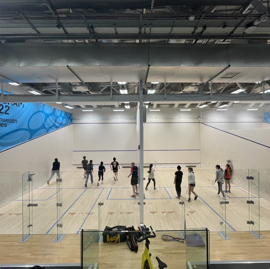 Two adjacent squash courses in use by students