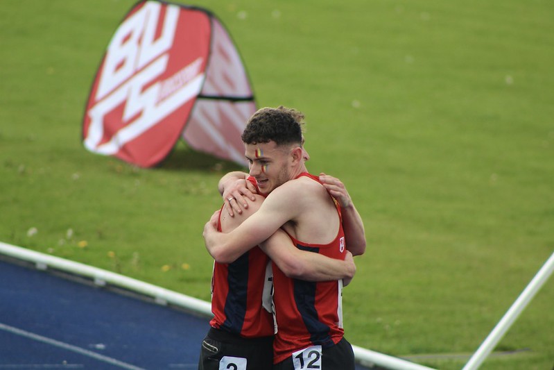 Male athletes hug at the finish line of the track at BUCS Outdoors 2023