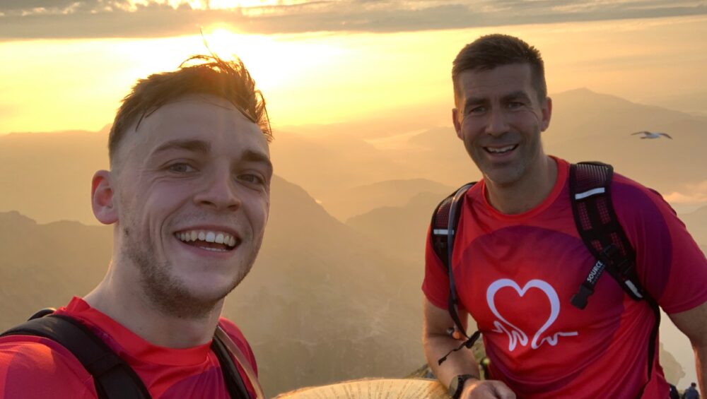 Selfie of Kacper and Ross at the top of a mountain with the sunset in the background