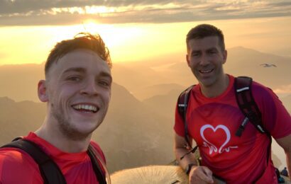 Selfie of Kacper and Ross at the top of a mountain with the sunset in the background