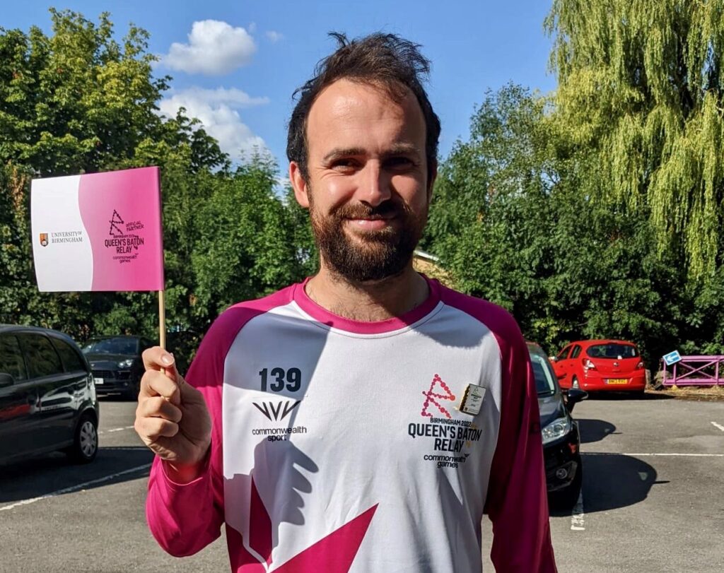 Image of Dean Miller holding baton in CWG branded tshirt