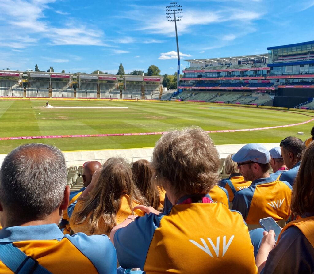 CWG volunteers sat on spectator seats overlooking sports field