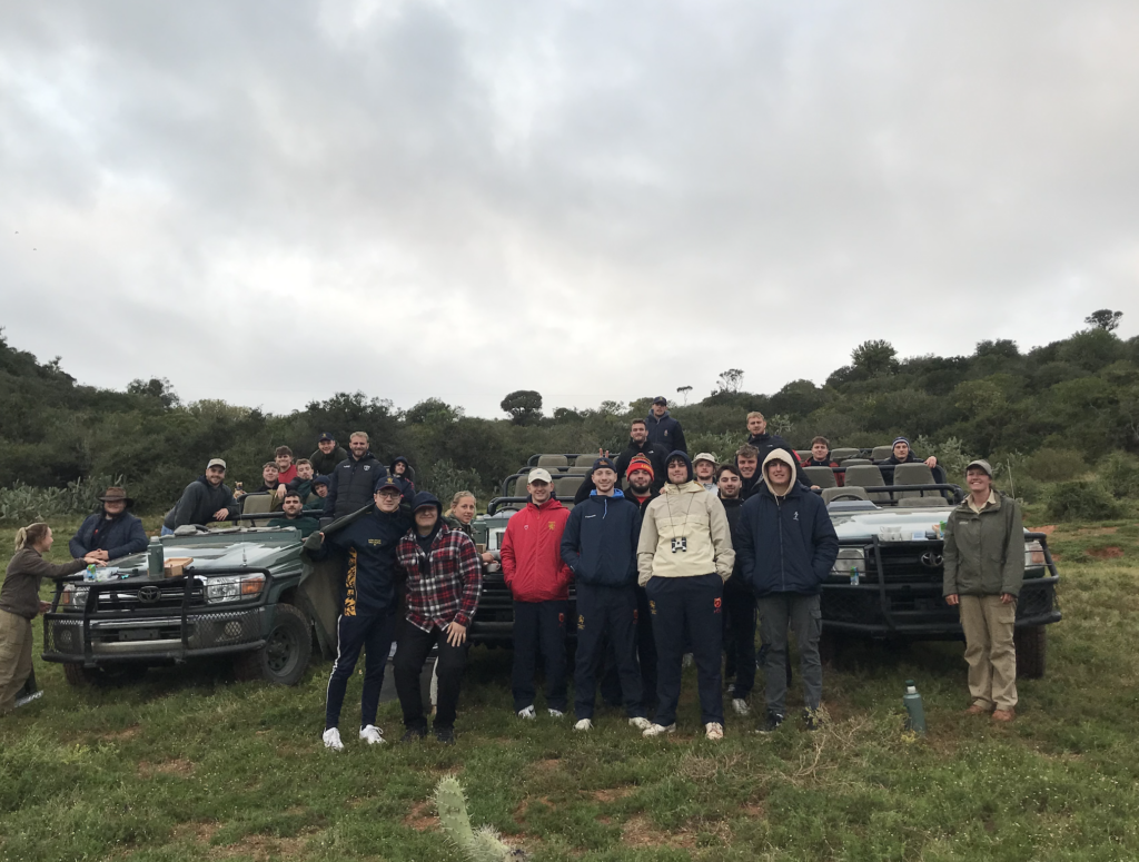 Rugby Union group photo standing in front of safari cars