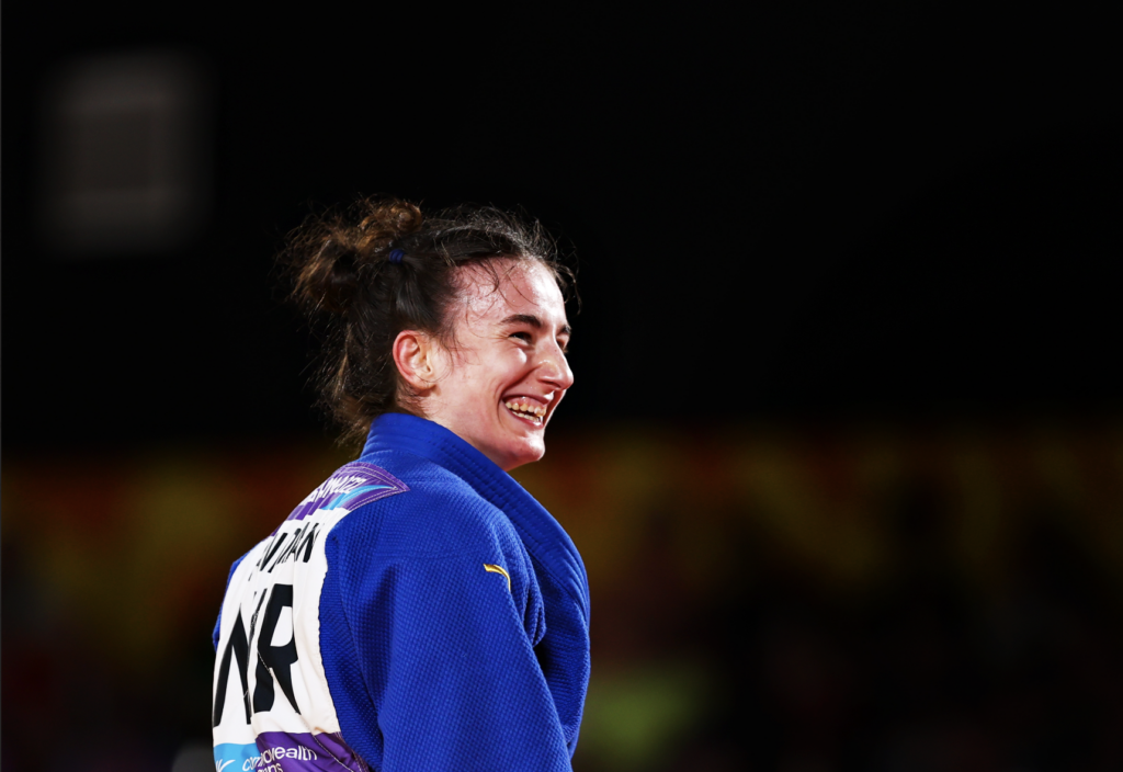 Yasmin smiling in Judo clothing under the stadium lights