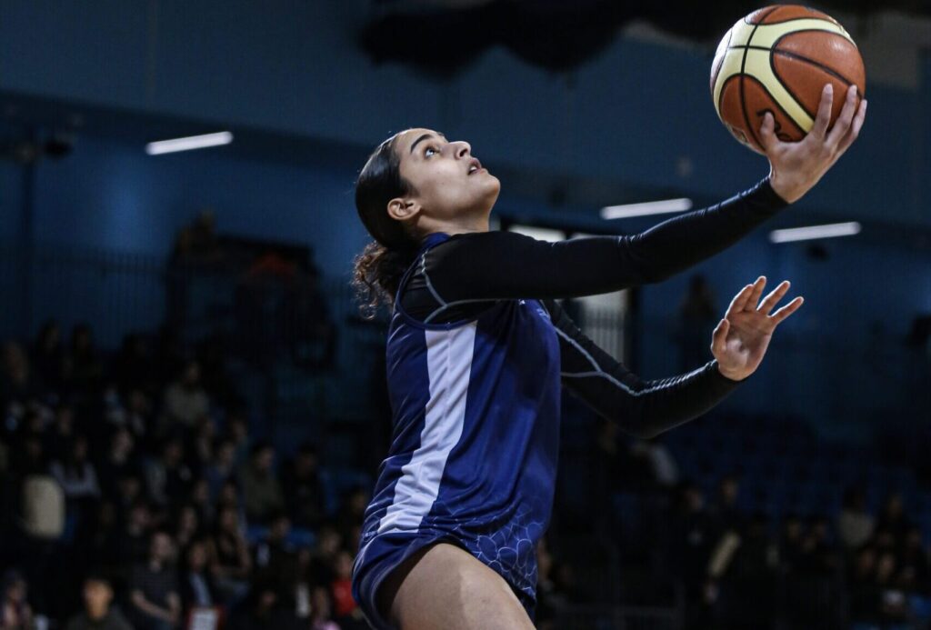 Women jumping in air about to take a shot at Rebellion basketball super series event