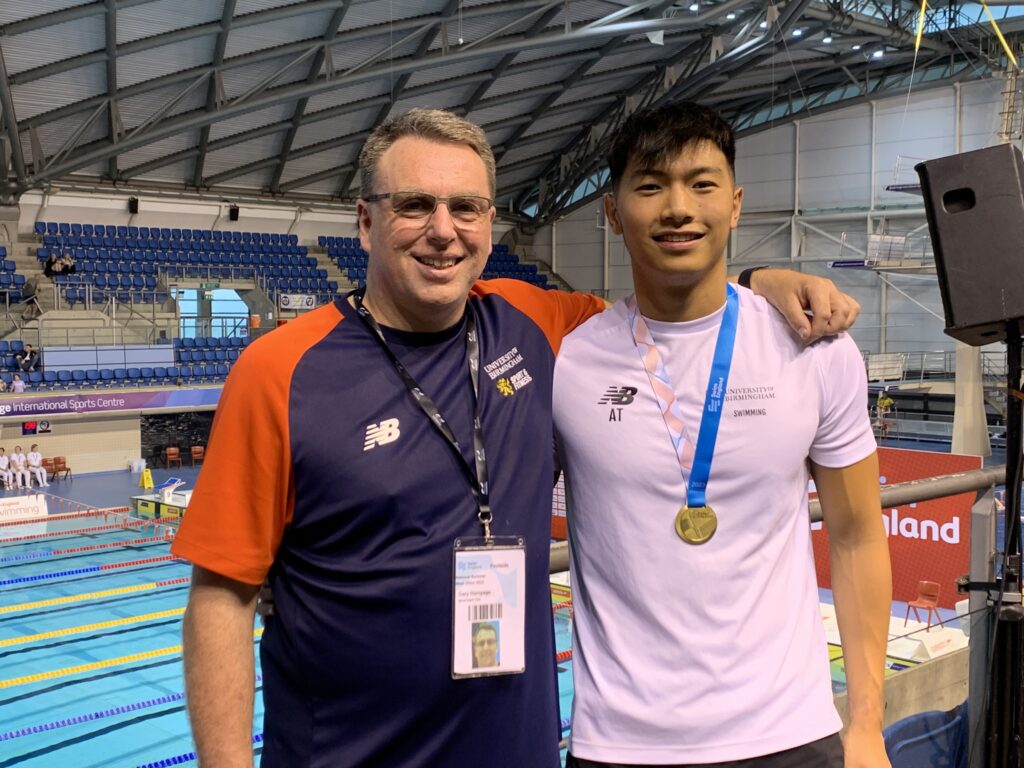 Coach Gary Humpage with arm around swim student Adrian Ting