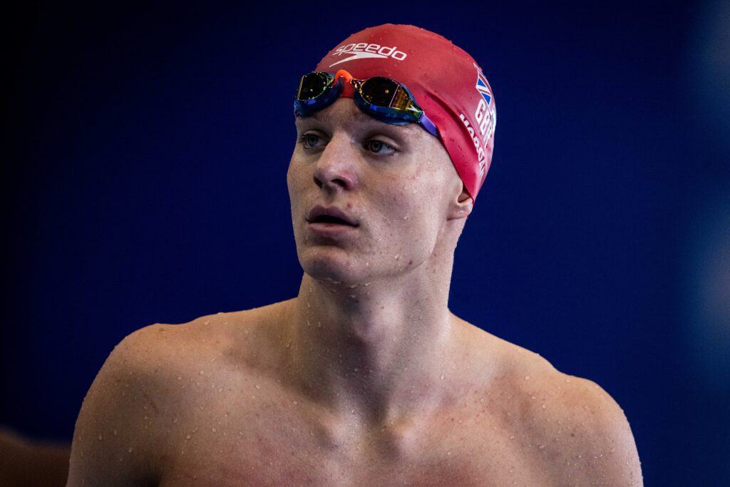 Close up shot of Ollie Morgan wearing red swim cap and goggles on head