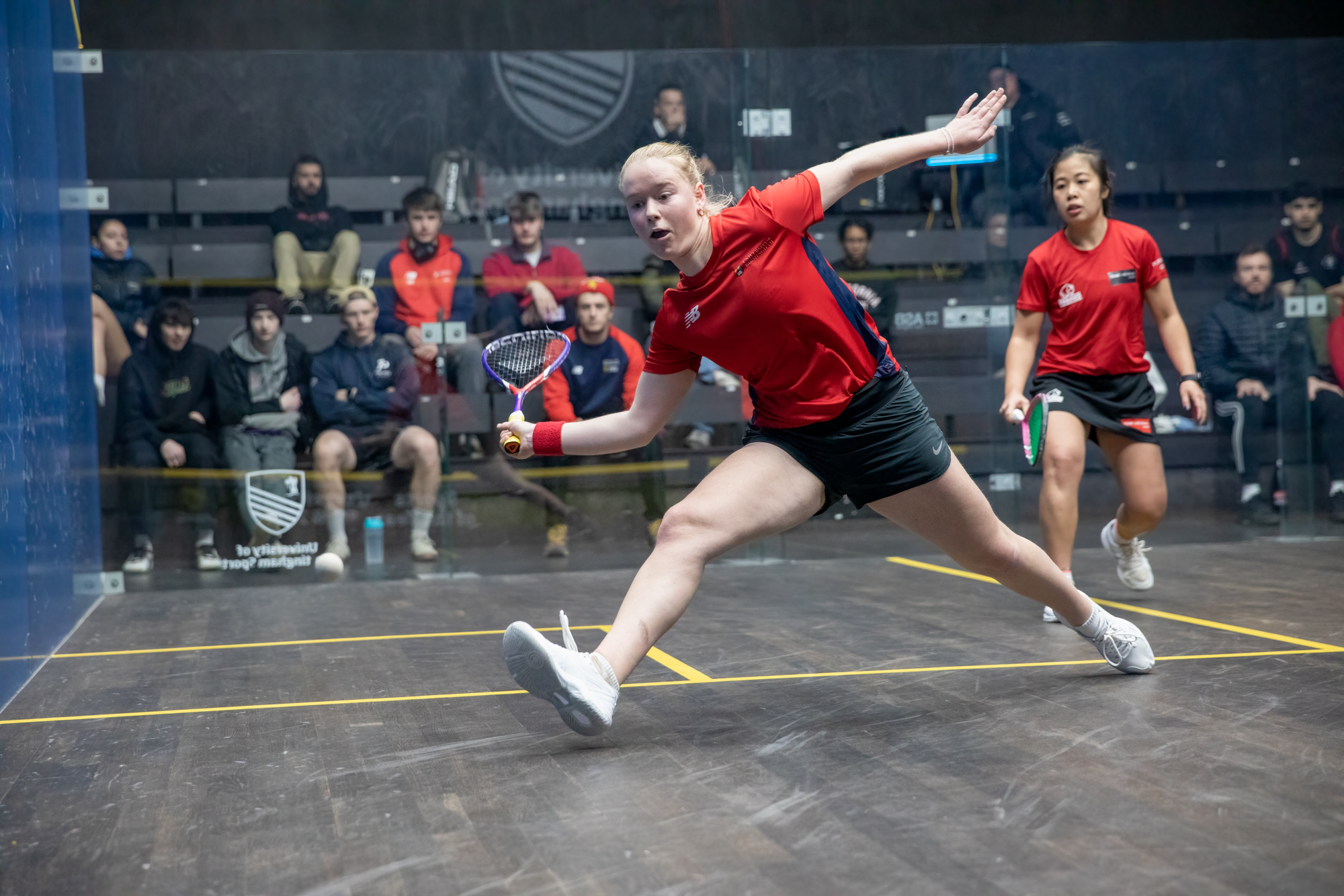 Performance Sqash Player, swinging to hit squash ball in court