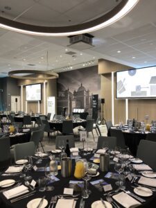 Room decorated for the Hall of Fame event - round table with black table cloth and programmes placed onto the table.