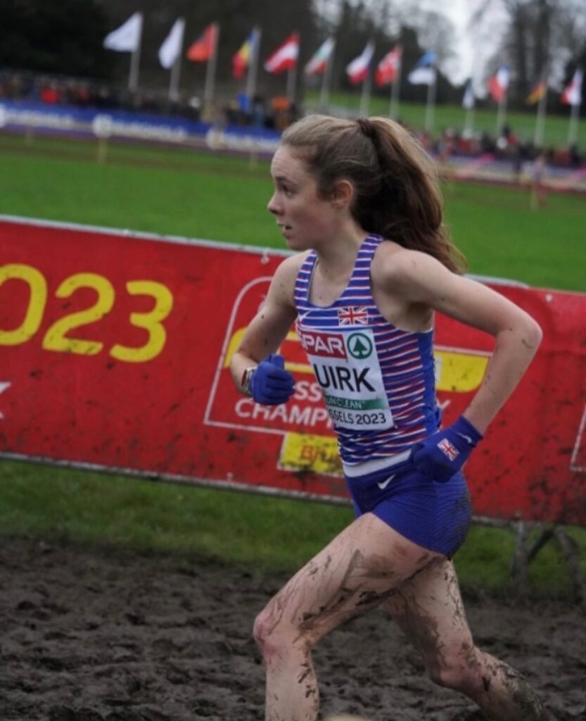 Amelia Quirk running through mud.