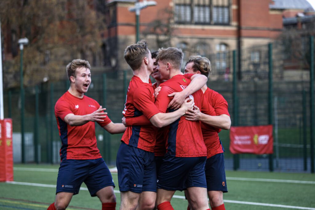 A group of footballers hugging eachother.