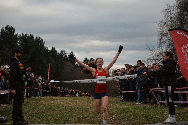 Amelia Quirk reaching the finish line, with arms raised in the air at the European Cross Country Championships.
