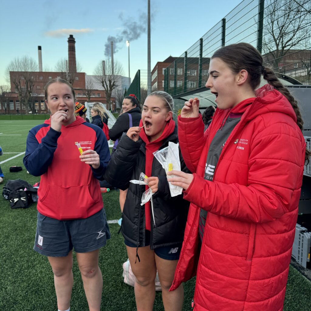 Rugby Women swabbing mouth with diagnostic marker.