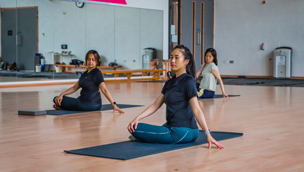 Three members attending yoga classes at Sport & Fitness.