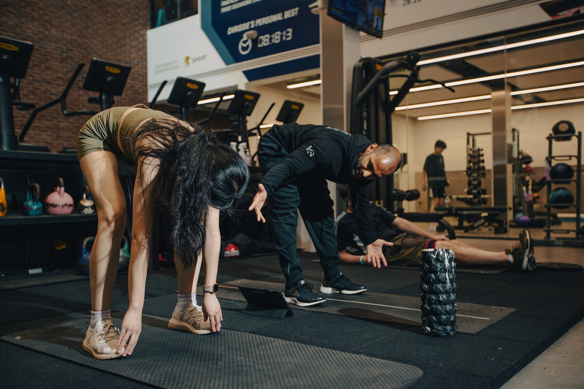 Gym Instructor supporting a member in Sport & Fitness gym.