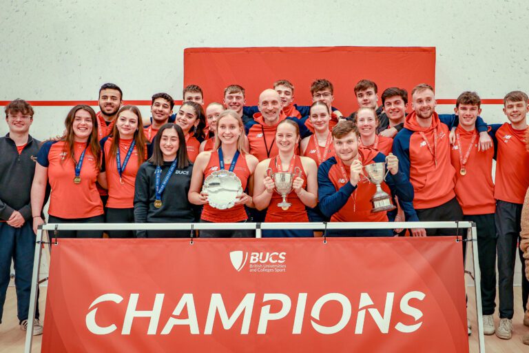 Men's and Women's Squash club winners hold trophy and stand behind Champions sign