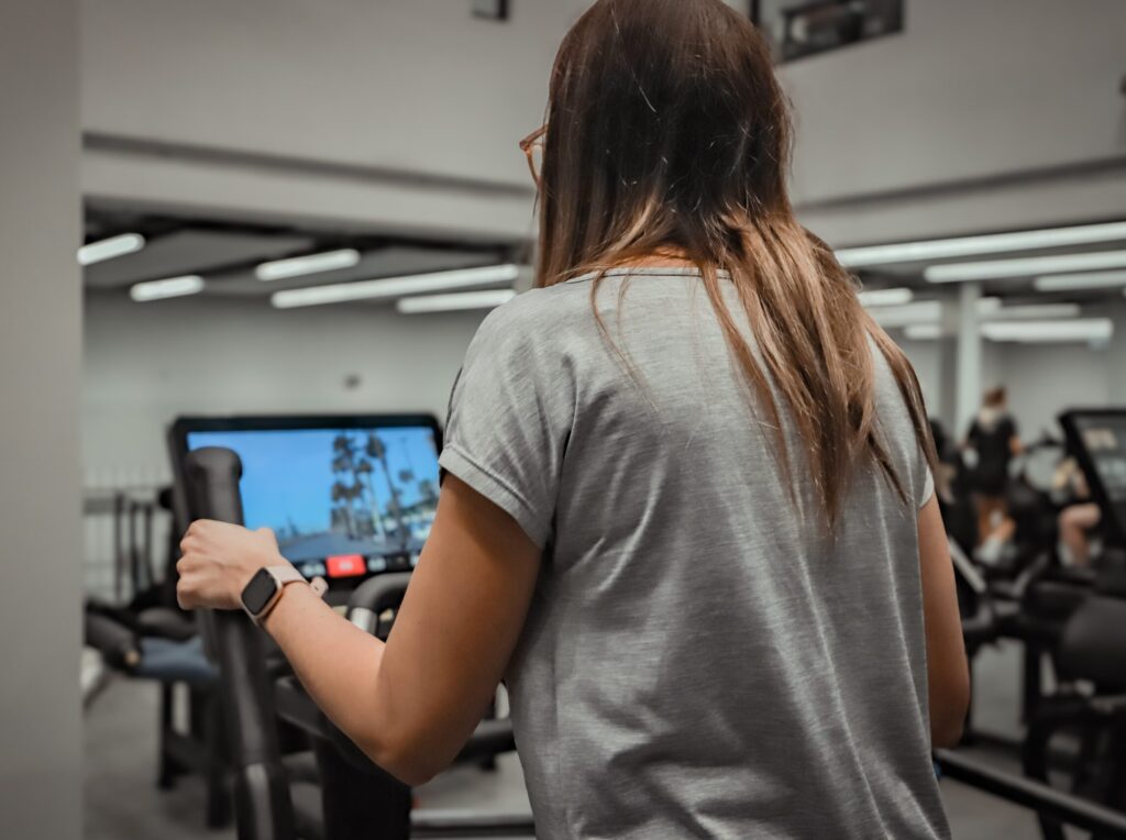 Behind view of girl on cross-trainer