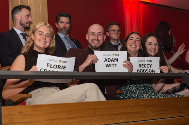 Sports Awards attendees holding name placeholders in spectator seats