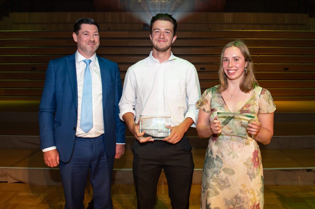 Students receiving plaque on stage