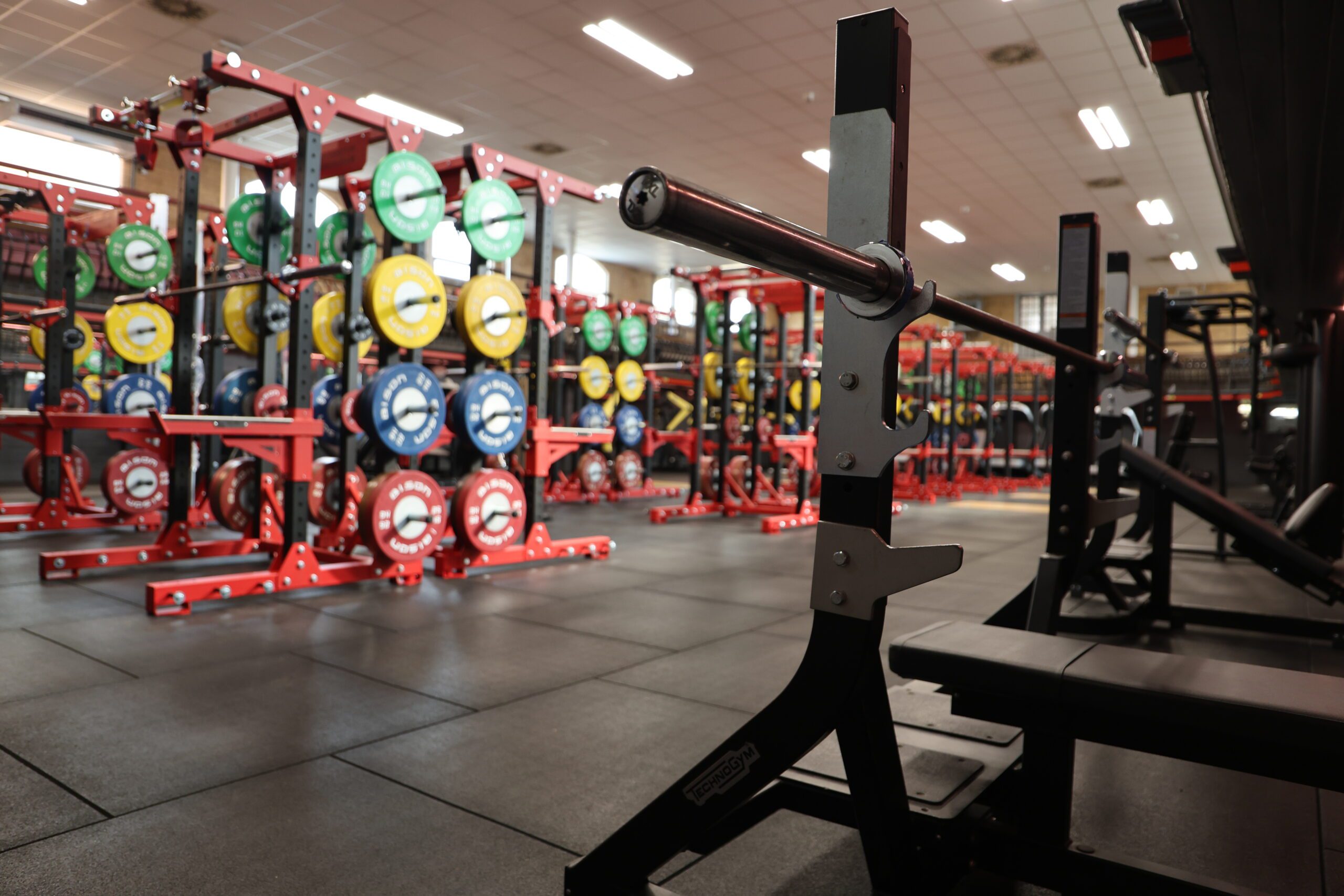 An image in Tiverton Gym, showcasing some of the lifting platforms and barbells.