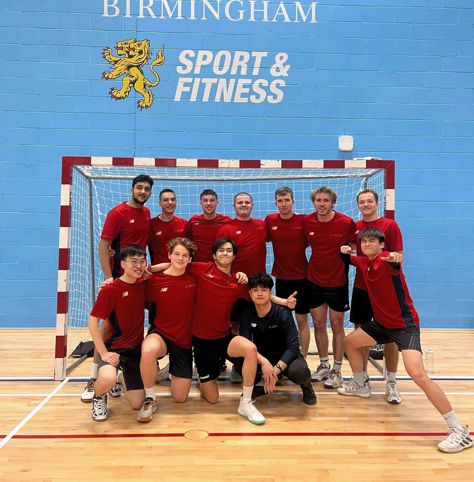 Handball group in front of a goal and the UoB Sport & Fitness logo.
