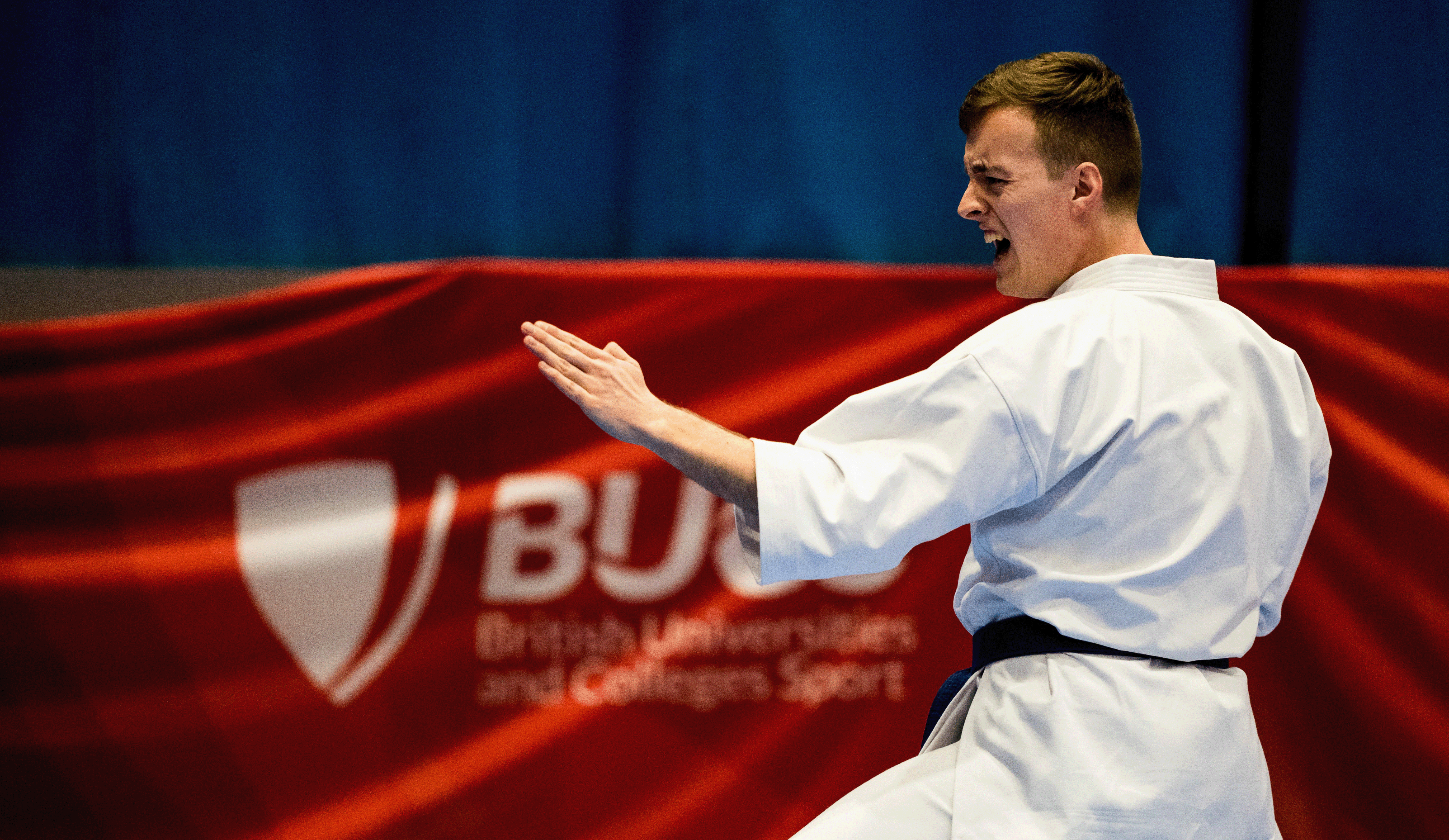 Male karate member competing at BUCS. Action shout he has his arms straight and appears to be shouting