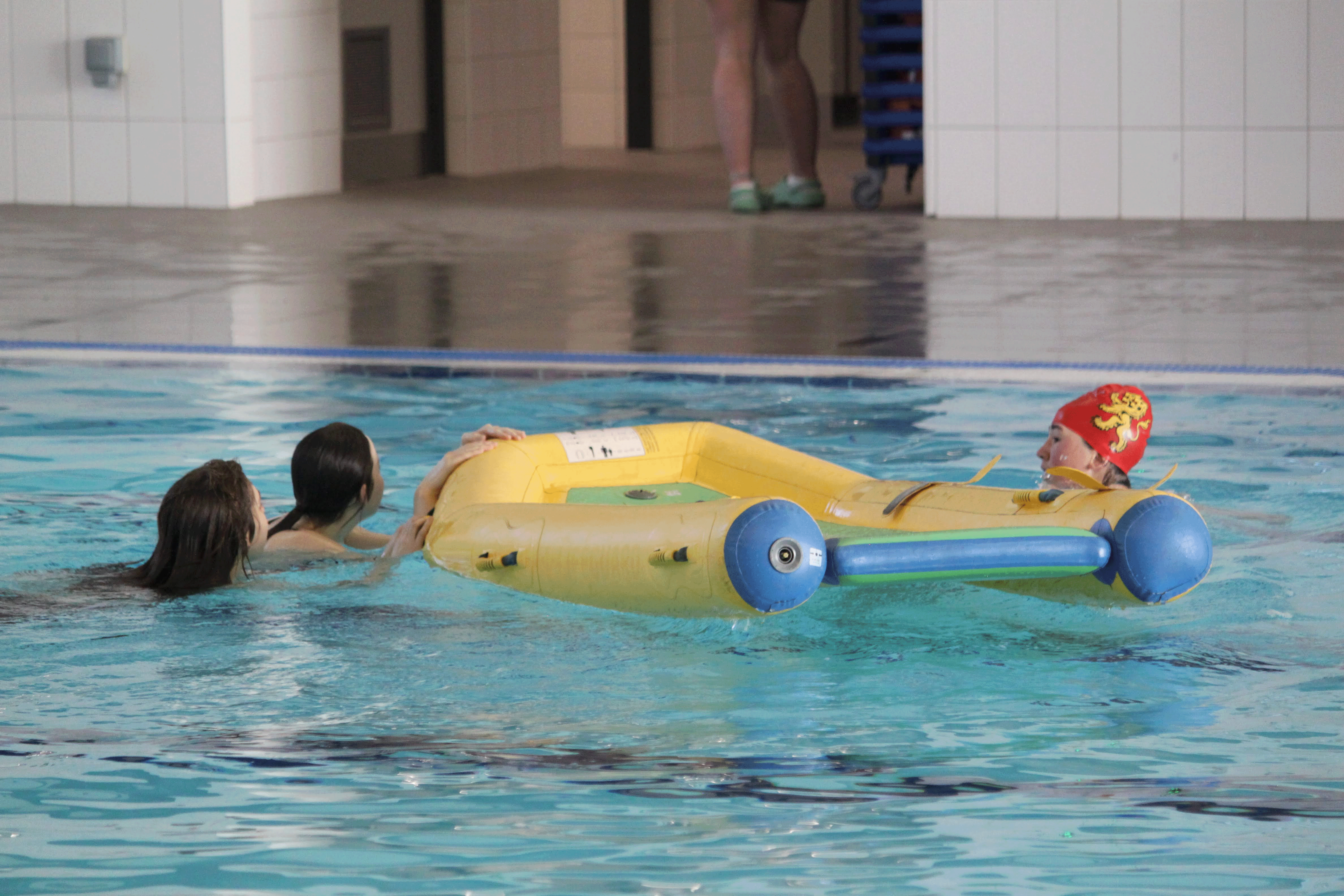 Pool image with a teammate rescuing casualties with an inflatable boat.