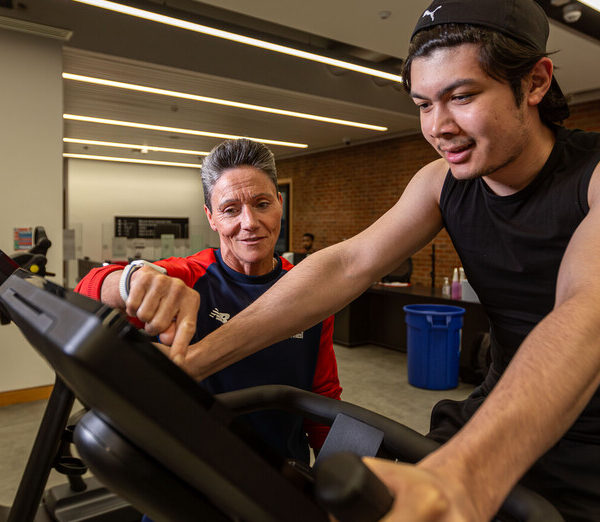 Janine, a gym instructor, supporting a member in Sport & Fitness gym.