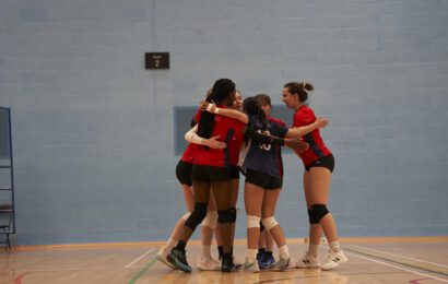 Women's volleyball team hugging