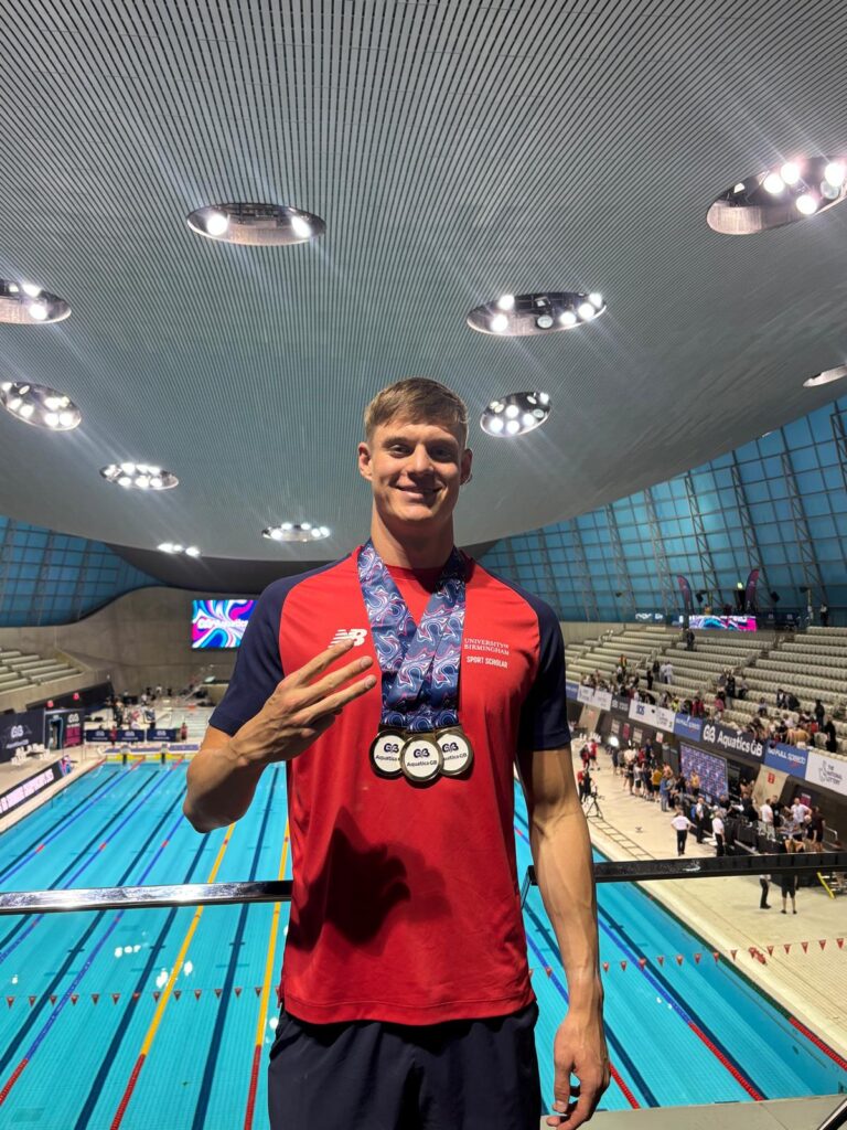 Ollie Morgan with 3 gold medals and holding up three fingers