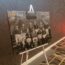 An image of a canvas printed with an old photo of the football team in black and white, balanced on an easel.