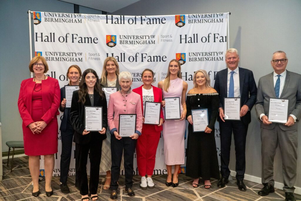 A group photo of our Hall of Fame inductees, stood in front of the Hall of Fame wall.