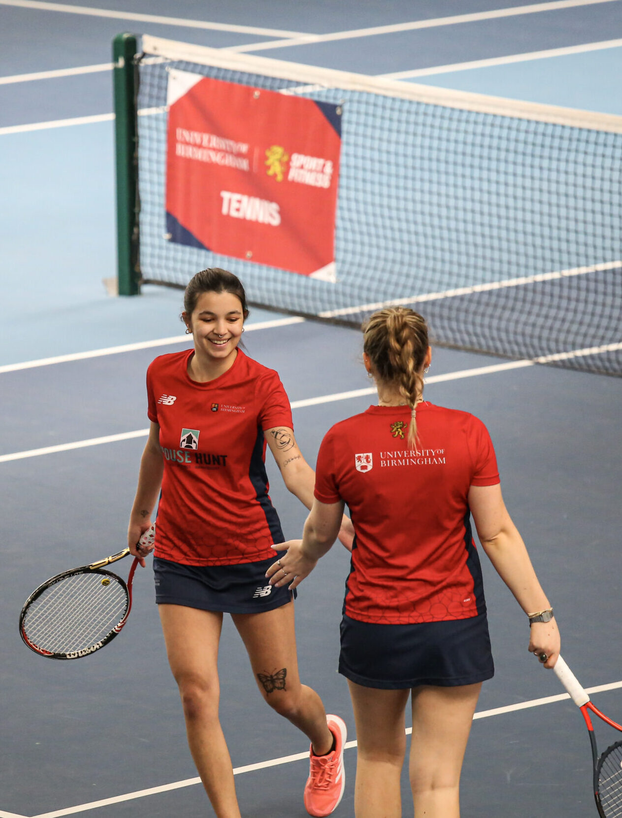 Two tennis players shaking hands on the University of Birmingham Tennis Courts.