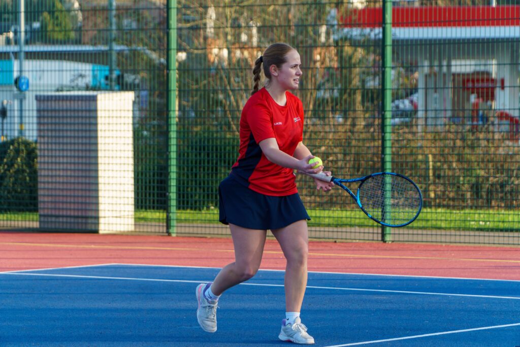 Tennis player returning a shot on the Tennis pitches on Edgbaston Campus