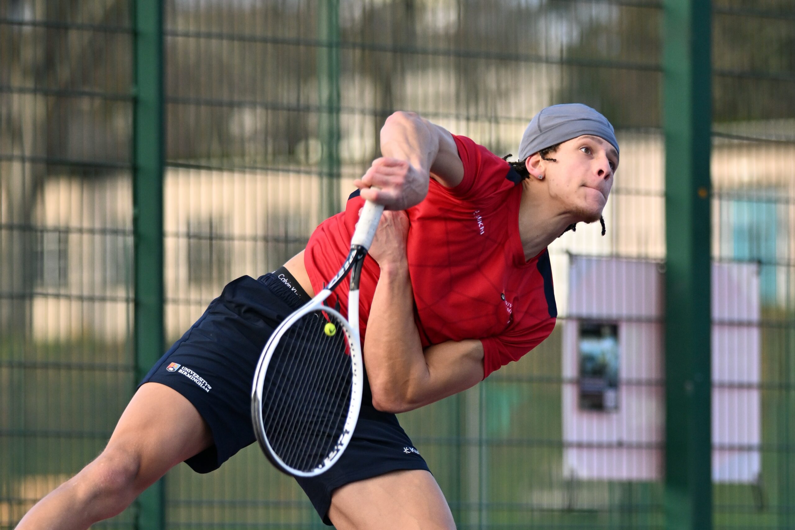 Tennis player serving on the Bournbrook Tennis Courts on the Edgbaston Campus