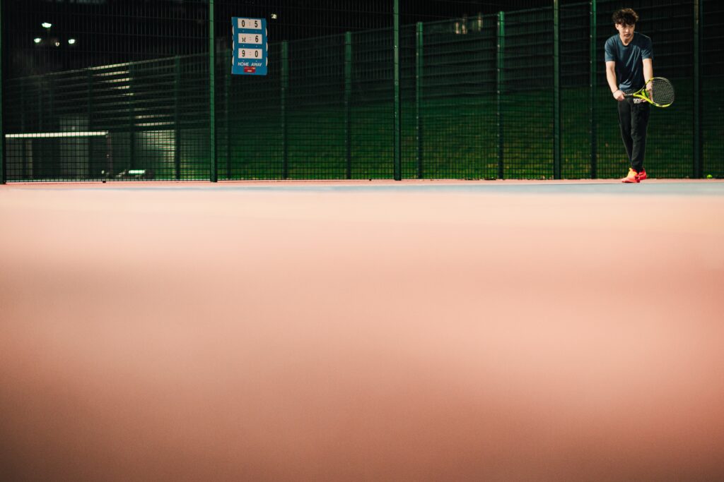 Tennis player preparing to serve on the Tennis Courts on Edgbaston Campus