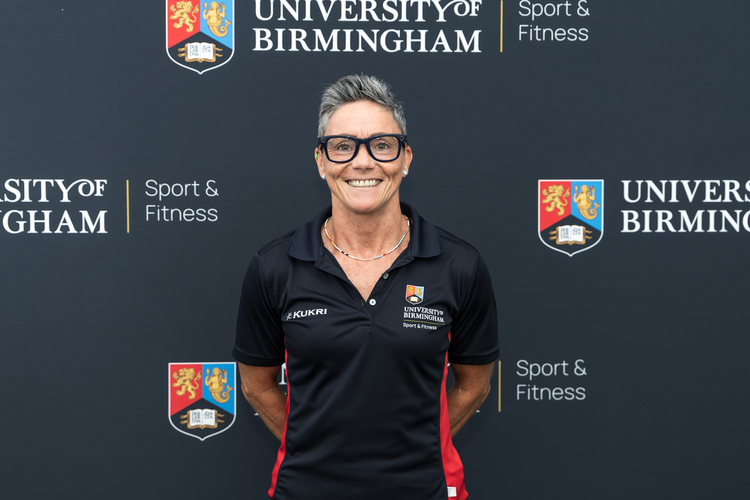 Woman smiling in front of backdrop.