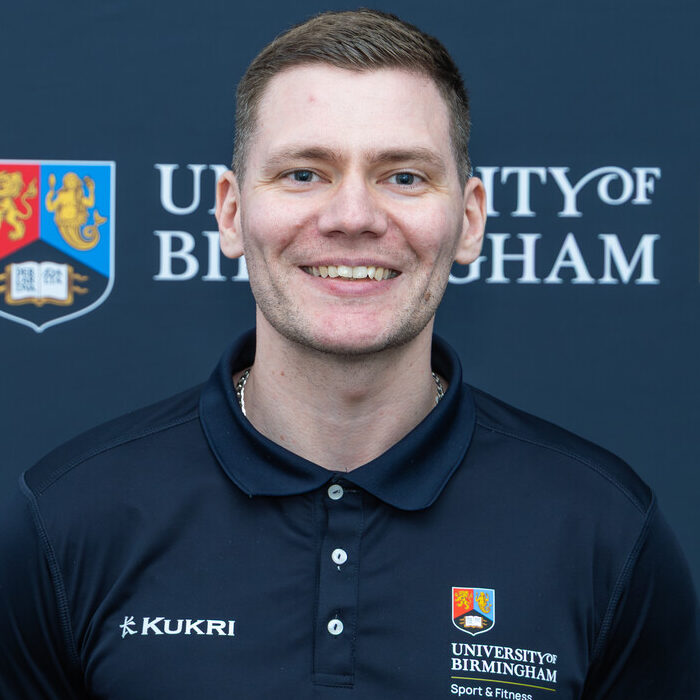 Man smiling in front of backdrop