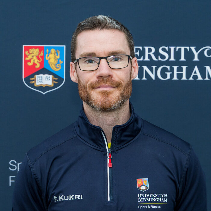 Man smiling in front of backdrop
