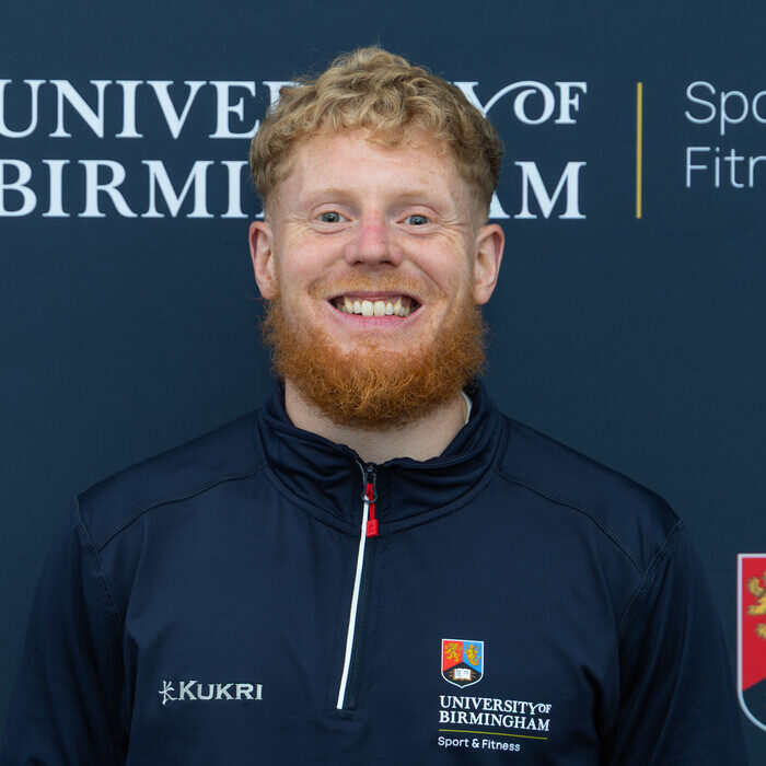 Man smiling in front of back drop